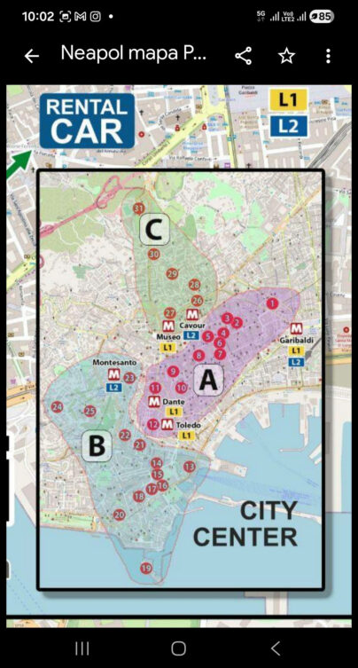 Mapa centrum Neapolu z podziałem na trzy obszary zwiedzania oznaczone literami A, B i C. Na planie zaznaczono numerowane atrakcje turystyczne, stacje metra linii L1 i L2 oraz główne trasy spacerowe po historycznym centrum miasta.